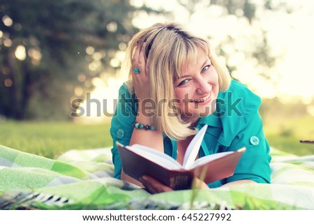 woman lay and read book sun