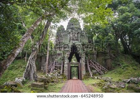 Scenic dappled jungle view of the Angkor Thom West Gate at the Angkor Temple complex near Siem Reap Cambodia