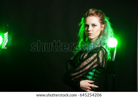 Fashion Woman in cosplay corset posing in studio with a green light from behind. Studio photo. Fashion and cosplay
