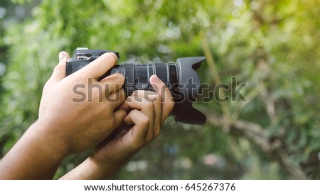 Close up, Yong man asian photographer holding digital camera DSLR with lens equipment for take a photo and picture memories travel landscape trip lifestyle.