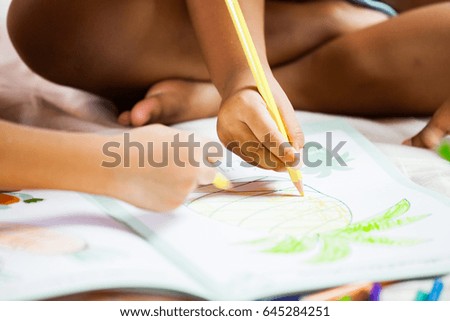 Focus on child hand holding the crayon is  painting her picture in vintage color tone