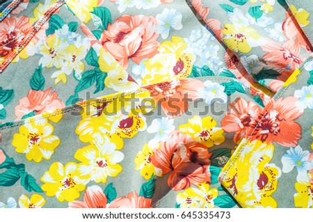 Texture, background, pattern. Girl's skirt. Silk fabric with floral pattern. Red Yellow Flowers
