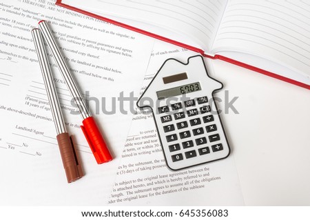 Calculator and contract on table - mortgage, real estate and buying house concept