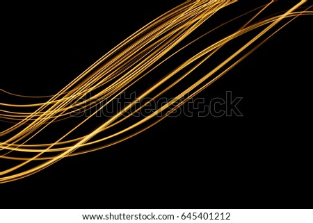 Gold Light Painting Photography, swoosh of light, parallel lines pattern against a black background
