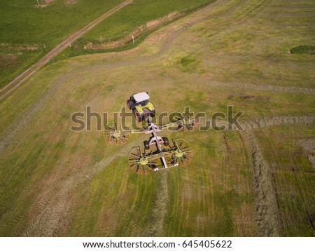 aerial view of a tractor on the green field at the haymaking - germany