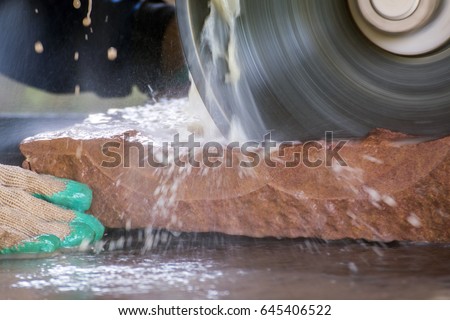 stone masonry concept, close up of cutting sandstone by industrial circular saw blades Royalty-Free Stock Photo #645406522