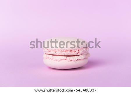 Picture of one sweet purple macaroon on purple table background.