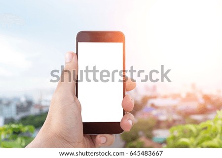 Man uses his Mobile Phone at cityscape background in morning light, close up, capture the moment by a smart phone in my hands. nature and cityscape background. building background.