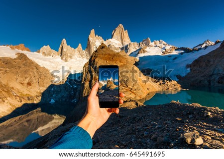 Taking a photo of mountains on a smartphone. Patagonia. Royalty-Free Stock Photo #645491695