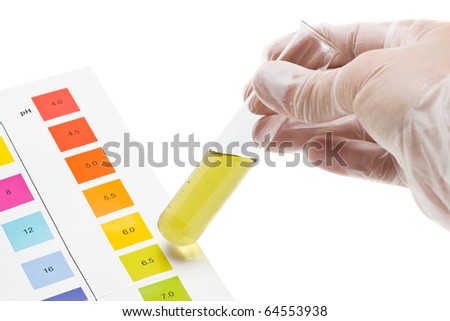 Hand holding test tube with pH indicator comparing color to scale Royalty-Free Stock Photo #64553938