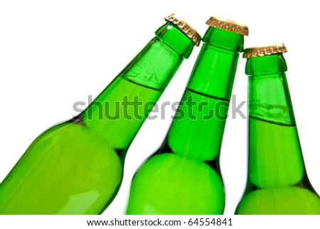 Three cold beers in green bottles on white background
