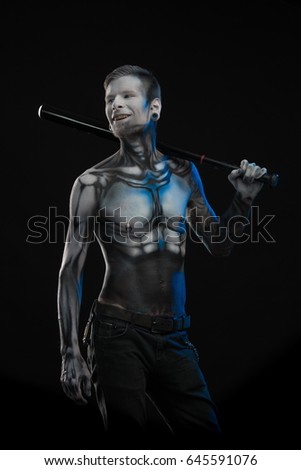 Portrait of a character for computer game a man with a picture on his body on a black background
Bodyart skeleton cyborg posing with baseball bat