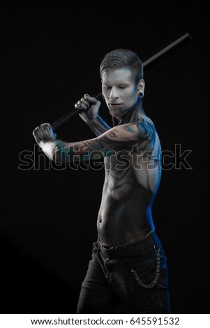Portrait of a character for computer game a man with a picture on his body on a black background
Bodyart skeleton cyborg posing with baseball bat