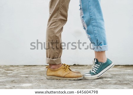 girls stands on tiptoe to kiss her man - Close up on shoes Royalty-Free Stock Photo #645604798