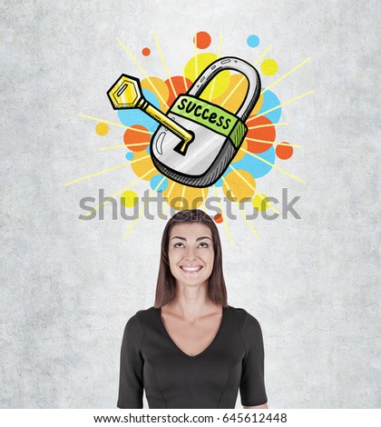 Portrait of a happy young woman with a wide smile standing near a concrete wall with a colorful key to success sketch above her head.