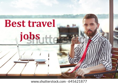 Concept of tourism and work. Young man drinking coffee in cafe on river shore. Text BEST TRAVEL JOBS on background