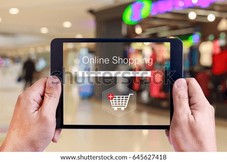 Online shopping concept on screen over blurred in shopping mall background