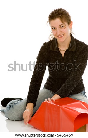 Young woman wrapping Christmas presents. Clear tape dispenser in her right hand. Isolated on white.