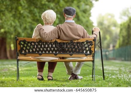 Rear view shot of a senior couple sitting on a wooden bench in the park Royalty-Free Stock Photo #645650875
