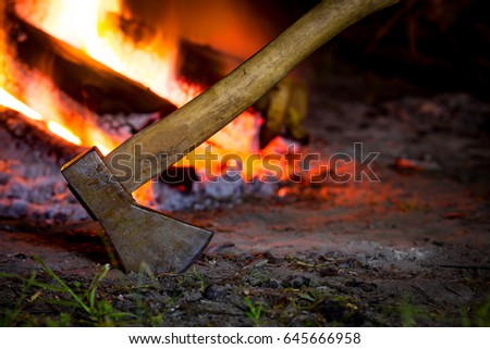Axe in darkness against hot fire