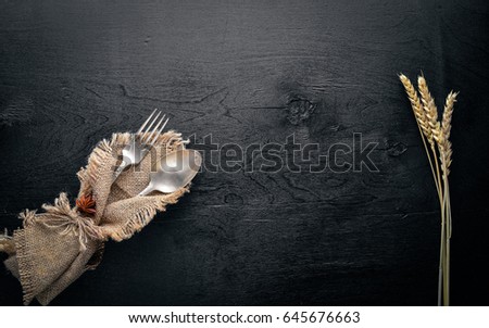 Cutlery, spoon and fork in old fabric on Wooden background. Top view. Free space.