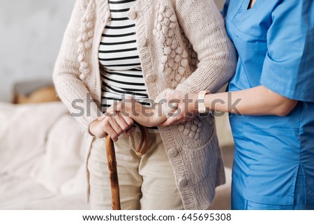 Gentle trained nurse helping mature patient Royalty-Free Stock Photo #645695308