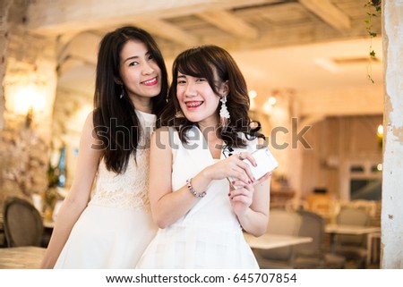 Beautiful young asian woman with her friend smiling at the cafe , friend concept