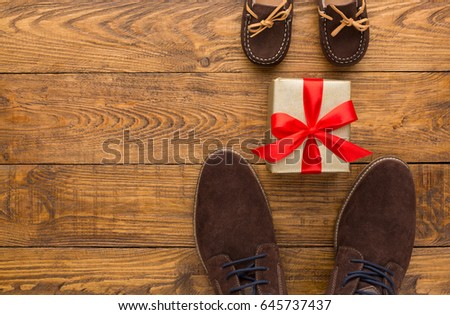 Happy Fathers Day card background on rustic wood with male and child shoes, copy space