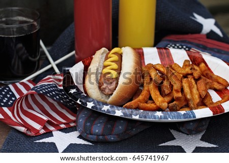 Hot dogs with Mustard at a 4th of July BBQ picnic. Extreme shallow depth of field with selective focus on wieners.