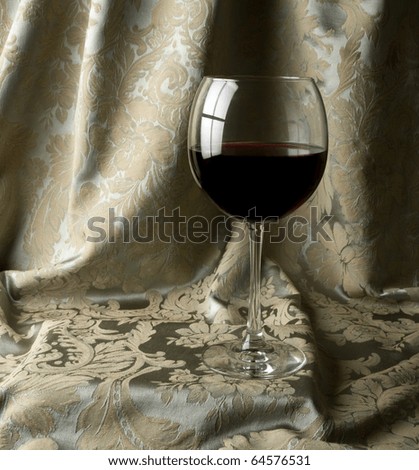Red Wine with a green damask draped background.