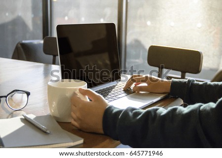 Student using laptop while having coffee at the coffee shop