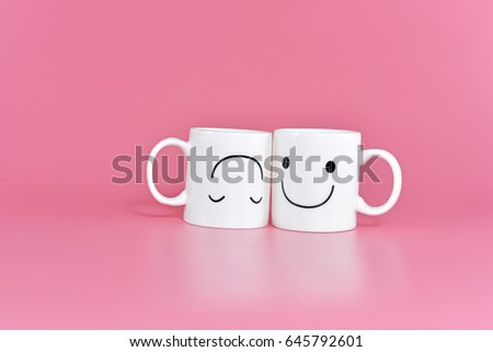 Two happy cups with marshmallows in the shape of heart on pink background. Concept about love and relationship. Creative colorful greeting card.