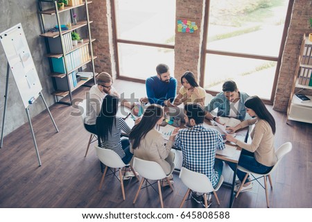Top view of partners  in casual clothes. They are focused, discussing the ideas for new start-up at nice comfortable  office Royalty-Free Stock Photo #645808588