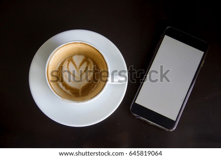 Coffee was eaten and smartphone on wooden table. View from above