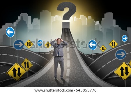 Businessman in uncertainty concept on road intersection crossroa
