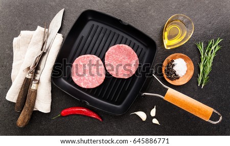 raw Chicken turkey burgers on grill pan with cutting Cutlery for slicing and spices