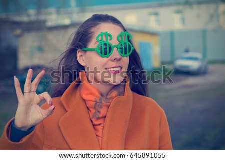Young woman in sunglasses with dollar sign