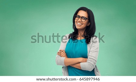 education, school and people concept - happy smiling young indian student woman or teacher in glasses over green chalkboard background