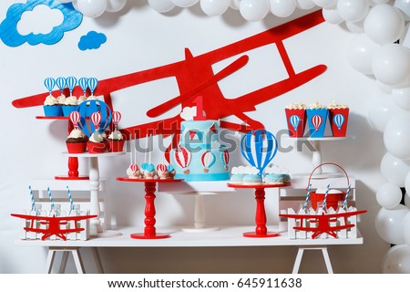 Candy bar on boy's birthday party with a lot of different candies, popcorn, beverages and big cake. Decorated in blue,red and white colors, balloons or aviation theme, indoor Royalty-Free Stock Photo #645911638