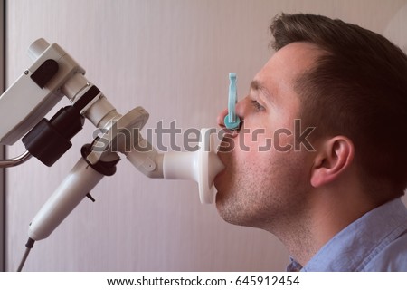 Young man testing breathing function by spirometry Royalty-Free Stock Photo #645912454
