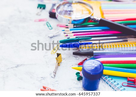 School supplies: colored pencils wooden yardstick erasers binders stationery gum paper clips pencil sharpener a small clothespin colored pins pencil and pen isolated on white background