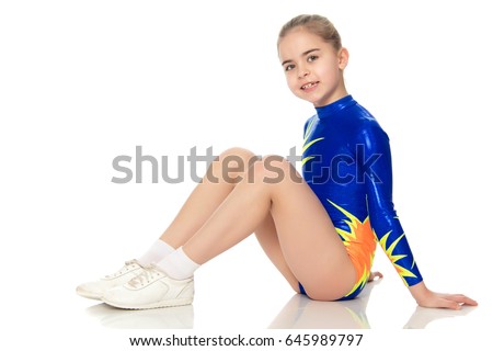 Beautiful Russian girl gymnast younger school age, in blue in a sports swimsuit.She performs a complex leap.Isolated on white background.