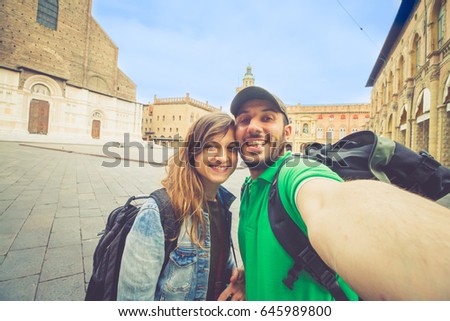 handsome tourist couple take selfie photo in Piazza maggiore (major square) in Bologna, Italy
