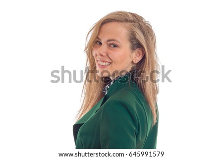 Portrait of a beautiful young blonde in a green jacket that stands sideways looks straight and smiling