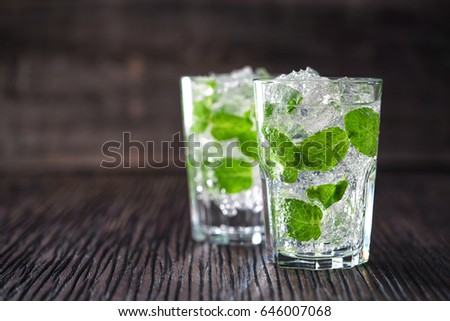 Glasses with non-alcoholic mojito cocktail on a wooden background, selective focus