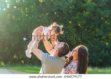 happy family concept - father, mother and child daughter having fun and playing in nature. Royalty-Free Stock Photo #646074577