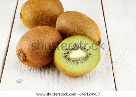 kiwi fruits and slice kiwi fruits on white wooden background