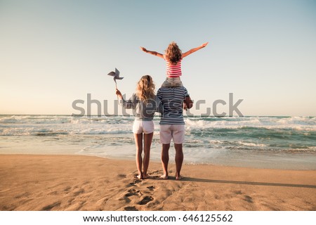 Happy family on the beach. People having fun on summer vacation. Father, mother and child against blue sea and sky background. Holiday travel concept Royalty-Free Stock Photo #646125562