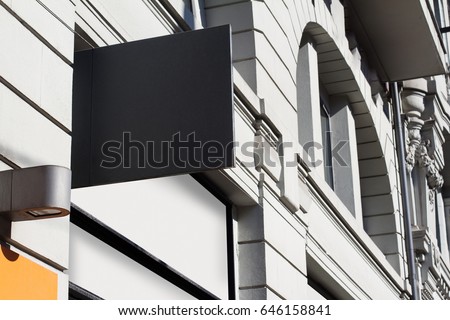 Horizontal front view of square empty black signboard on a white building with classical architecture