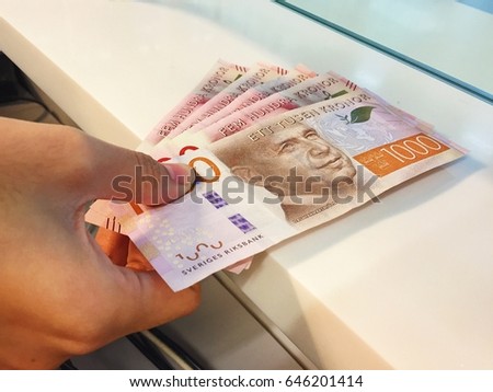 Woman holding new Swedish bank notes giving for customers who exchange money. New Swedish bank notes. NOTE: the new 2015 model. Sweden krona, Sweden Money, Sweden Currency. Royalty-Free Stock Photo #646201414